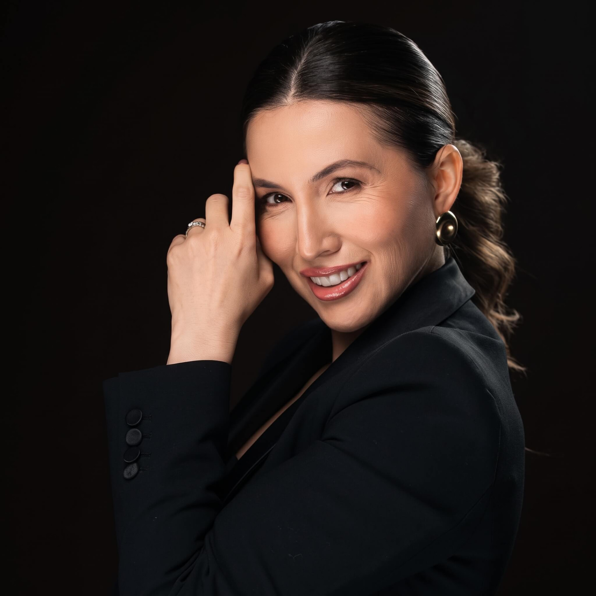 Vanessa Goltzman sorrindo com blazer preto